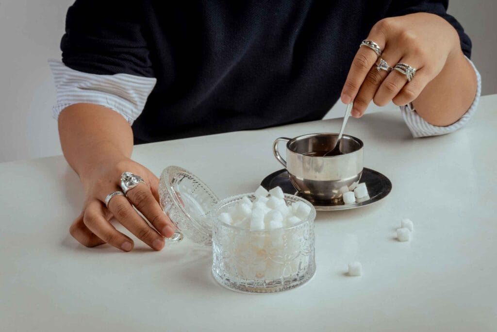 une femme met du sucre dans son café