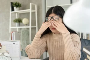 Une femme qui rougit et qui se sent mal à la suite d’une situation stressante.